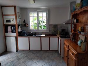 a kitchen with white cabinets and a window at beautiful apartment with garden in Amélie-les-Bains-Palalda