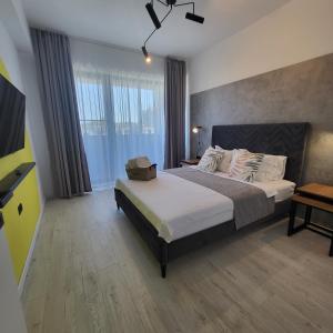 a bedroom with a bed with a television on it at KuuB Apartments in Constanţa