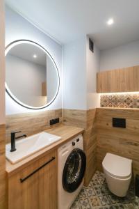 ein Badezimmer mit einer Waschmaschine und einem Waschbecken in der Unterkunft Wisła - Centrum, Apartament z Wiślaczkiem - Dream Apart in Wisła