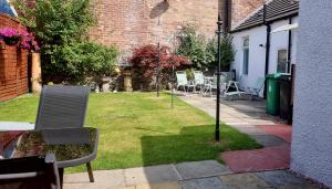 a garden with chairs and a table and a building at The Coal House in Townhill