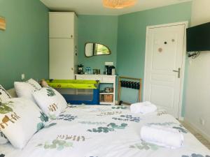 een slaapkamer met een groot bed met groene muren bij Au petit bonheur de Claire et Jo in La Chapelle-Caro