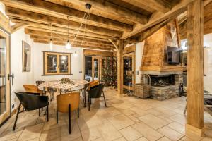 une salle à manger avec une table, des chaises et une cheminée dans l'établissement Chalet savoyard d'exception avec piscine chauffée, à Bourg-Saint-Maurice