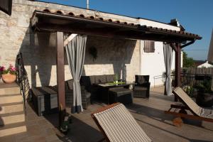 drewniana pergola ze stołem i krzesłami na patio w obiekcie Stellar House Višnjan w mieście Višnjan