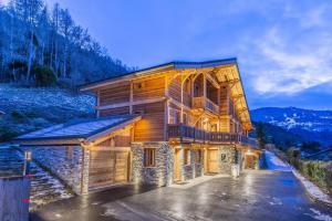 una gran casa de madera con muchas ventanas en Chalet savoyard d'exception avec piscine chauffée, en Bourg-Saint-Maurice