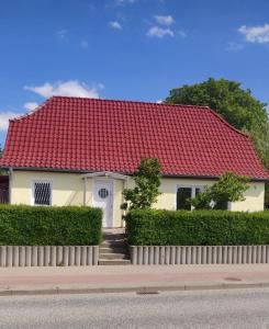 ein weißes Haus mit rotem Dach in der Unterkunft Ferien im Fischerhaus in Wismar