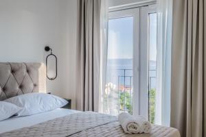 een slaapkamer met een bed en een groot glazen raam bij Apartment House Vista in Crikvenica +22 foto's
