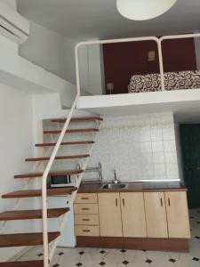 a kitchen with a staircase leading up to a loft at Apartamentos Balcón de Maro in Maro
