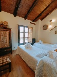 a bedroom with two beds and a window at La Cabana´l Cachican in Cangas del Narcea