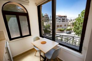 Julia's Hotel Suites في عمّان: طاولة صغيرة وكرسيين في غرفة بها نافذة