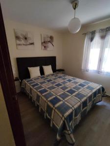 1 dormitorio con 1 cama con manta de cuadros azul en Casa Valentín, en Casillas