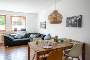 sala de estar con mesa y sofá en Alpenraum, en Bad Hindelang