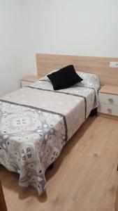 Cama en habitación con suelo de madera en Casa MENDEZ - ALLARIZ, en Ourense