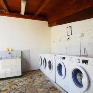 a laundry room with three washing machines in it at H&S Mobile Home in Privlaka