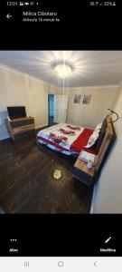 1 dormitorio con cama, mesa y lámpara de araña en Residence Manu Targu Neamt, en Tîrgu Neamţ