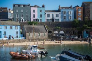 a group of boats in the water next to a beach at Gwynne House - 6 Bed Holiday Home - Tenby Harbour in Tenby