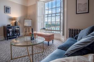 a living room with a couch and a glass table at Gwynne House - 6 Bed Holiday Home - Tenby Harbour in Tenby