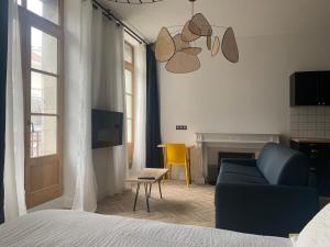 - une chambre avec un canapé bleu et un fauteuil jaune dans l'établissement Pau's Appart - Pau Centre, à Pau