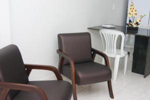 a room with two chairs and a table and a chair at Areia Branca Apart Hotel in Areia Branca