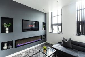 a living room with a couch and a tv on a wall at Spire Accommodations Ltd in Bradford