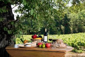 a table with a bottle of wine and fruits and vegetables at Bastide de Fave in Brue-Auriac