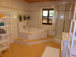 un bagno con vasca, doccia e lavandino di Haus Hütter ad Altaussee