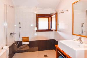 a bathroom with a sink and a toilet and a mirror at Encantadora casa con espectaculares vistas in Ajo +14 photos