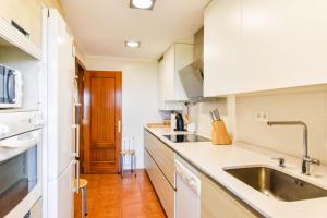 a kitchen with white cabinets and a sink at Encantadora casa con espectaculares vistas in Ajo