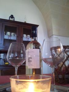 a bottle of wine sitting next to two wine glasses at Villa Pugliese in Savelletri di Fasano