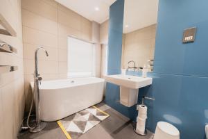 a bathroom with a white tub and a sink at Marylebone Town House in London