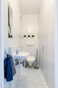 a white bathroom with a sink and a toilet at SuperApart Krzywoń 8 ROOMS in Warsaw