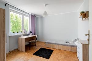 a bedroom with a bed and a desk and a table at SuperApart Krzywoń 8 ROOMS in Warsaw