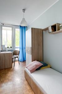 a bedroom with a bed and a desk and a chair at SuperApart Krzywoń 8 ROOMS in Warsaw