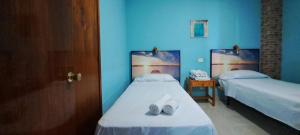 2 łóżka w pokoju z niebieskimi ścianami w obiekcie Tinache Beach 103 Maspalomas w mieście San Bartolomé