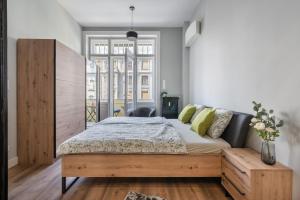 1 dormitorio con 1 cama con cabecero de madera en BUENOS Boutique - A/C, 2 bathrms, amazing view en Budapest
