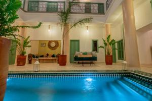 een zwembad in een huis met een woonkamer bij Riad Trésor Marrakech in Marrakesh