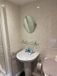 a bathroom with a toilet and a sink and a mirror at The Mill Inn in Penrith