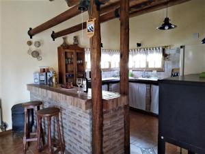 cocina con barra con taburetes y encimera en Brisas de viñedos en Luján de Cuyo