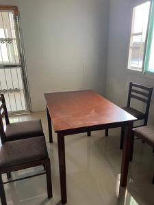 a wooden table and two chairs in a room at อาร์ทู R2 RongKhun in Chiang Rai