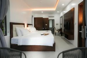 a bedroom with a large white bed and a television at DAD Resort Phú Quốc in Phú Quốc