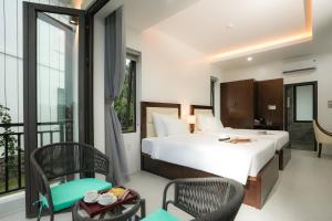 a bedroom with a large bed and a balcony at DAD Resort Phú Quốc in Phú Quốc