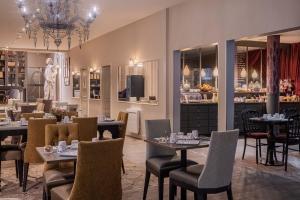 a dining room with tables and chairs and a store at Hôtel Littéraire Gustave Flaubert, BW Signature Collection in Rouen