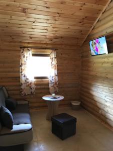 a room in a log cabin with a table and a window at Ignaszówka in Radawa
