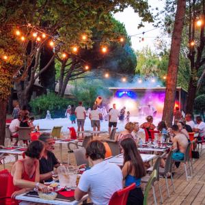 a group of people sitting at tables in front of a concert at Marina Hôtel Club in Cogolin +67 photos