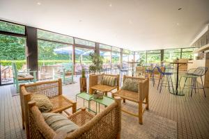 een grote kamer met stoelen, tafels en ramen bij Urban Gardens Gent in Gent