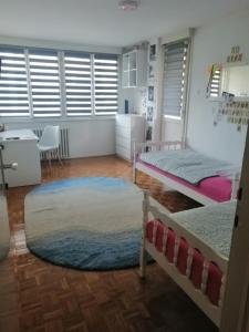 a bedroom with two beds and a rug at HomeB&E in Tuzla