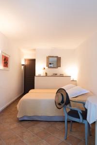 a bedroom with two beds and a hat on a chair at Bastide de Fave in Brue-Auriac