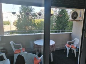 a balcony with a table and chairs and a window at HomeB&E in Tuzla