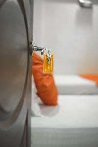 an orange pillow with a tag attached to a door at GOHO Rooms Badar in Karachi