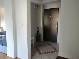 a hallway with a black door and a rug at HomeB&E in Tuzla