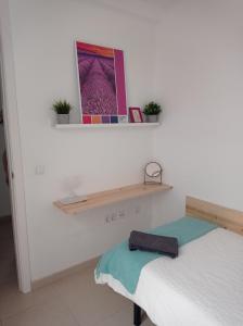 a bedroom with a bed and a shelf on the wall at Cañete 4 in Las Lagunas